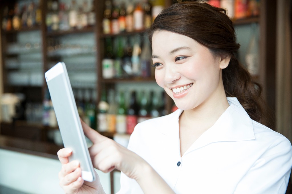 タブレットで注文を確認する店舗スタッフ